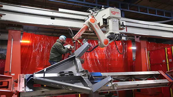 Robotic welding technician works with manufacturing robot